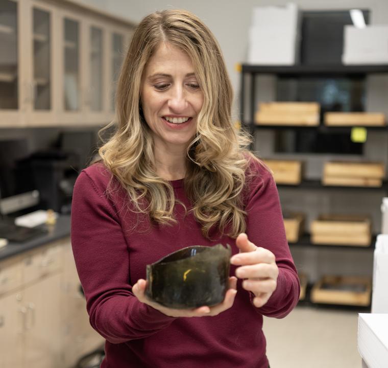 Dr. Julie Markin holds an artifact from a recent regional excavation